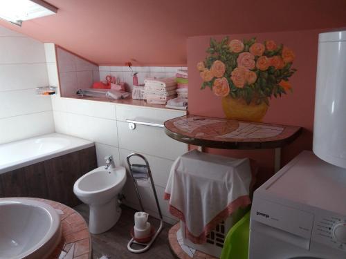 a bathroom with a sink and a toilet and a vase of flowers at Leonika Portorož in Portorož