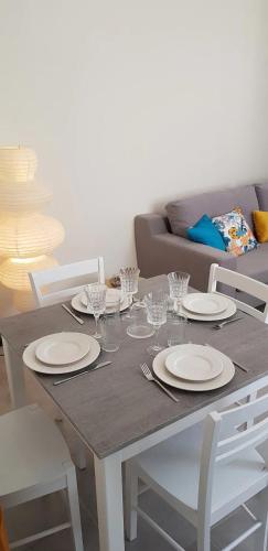 une table de salle à manger avec des assiettes et des verres dessus dans l'établissement Le Gite de Myla au pied du Château Royal d'Amboise, à Amboise