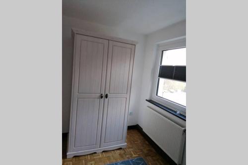 a room with a white cabinet and a window at Ferienwohnung Ankerplatz am Sorpesee in Langscheid