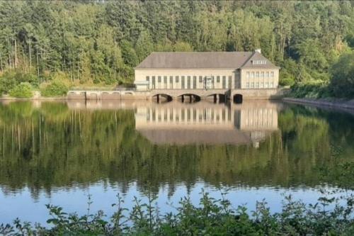 a building sitting on the side of a lake at Ferienwohnung Ankerplatz am Sorpesee in Langscheid