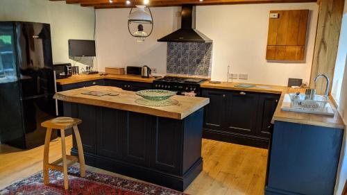 a kitchen with black cabinets and a counter top at Yr Hen Feudy in Barmouth