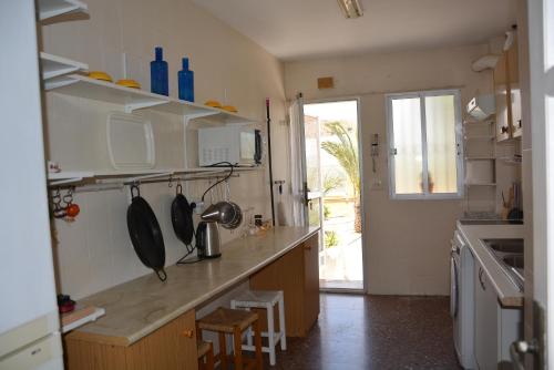 cocina con encimera, fregadero y ventana en LOS ALAMILLOS 3 Piscina, CAMPO DE FUTBOL y jardin PRIVADOS, en Mazarrón