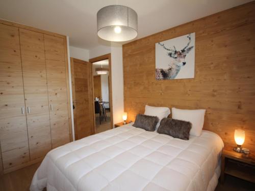 オトリュスにあるAppartement Hauteluce, 3 pièces, 6 personnes - FR-1-293-268の木製の壁のベッドルーム1室(白い大型ベッド1台付)