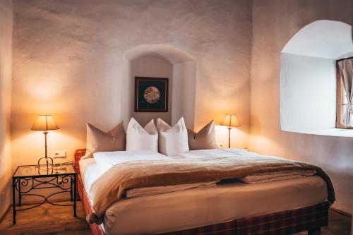 a bedroom with a large bed with two lamps at Hotel Goldener Engl in Hall in Tirol