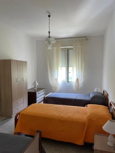 a bedroom with two beds and a window at Casello sul Mare in San Nicola Arcella