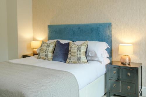 1 dormitorio con 1 cama con cabecero azul y 2 lámparas en The Water Rat Ironbridge en Ironbridge