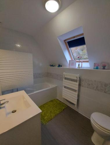 une salle de bain avec une baignoire, des toilettes et un lavabo dans l'établissement Les Suites de Véronique, chez Véronique Olive, à Saint-Pair-sur-Mer