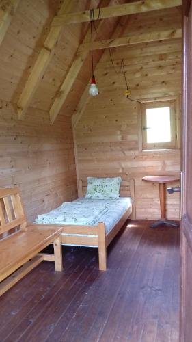 a room with a bed in a wooden cabin at Kamp Rafting Kljajevića Luka in Pljevlja