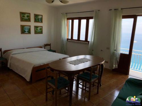 a bedroom with a bed and a table with chairs at Magi - Il Tramonto su Palmarola in Ponza