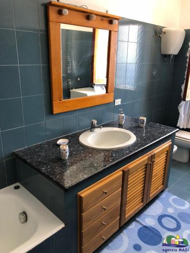 a bathroom with a sink and a mirror and a tub at Magi - Il Tramonto su Palmarola in Ponza