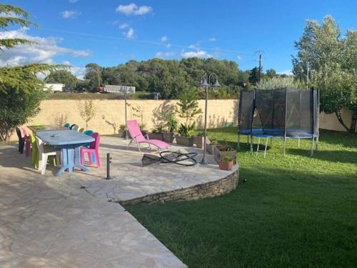 a patio with a table and chairs in a yard at Villa SPA Piscine : entre mer et montagne in Foissac