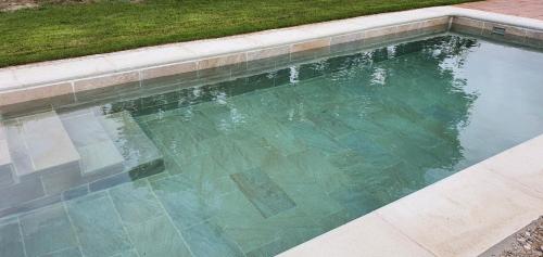 a swimming pool with clear water in a yard at casa Rural Las Traviesas in Candeleda