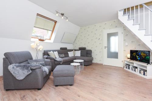 ein Wohnzimmer mit Couch und Fernseher in der Unterkunft Ferienhaus Windspiel in Neuharlingersiel