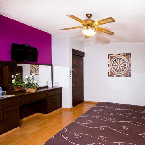 a living room with a ceiling fan and purple walls at Hotel & Motel Hacienda Jiutepec in Jiutepec