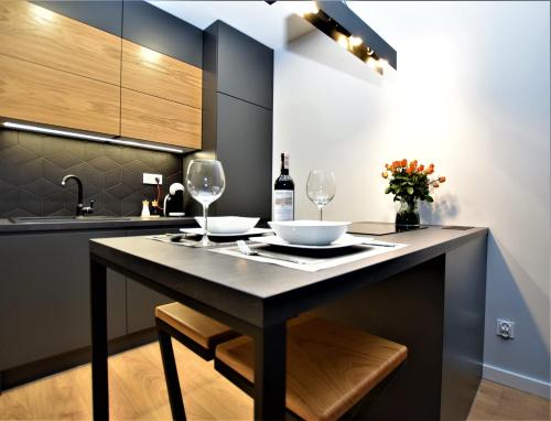 uma cozinha com uma mesa e dois copos de vinho em Premium Apartments Rzeszów em Rzeszów