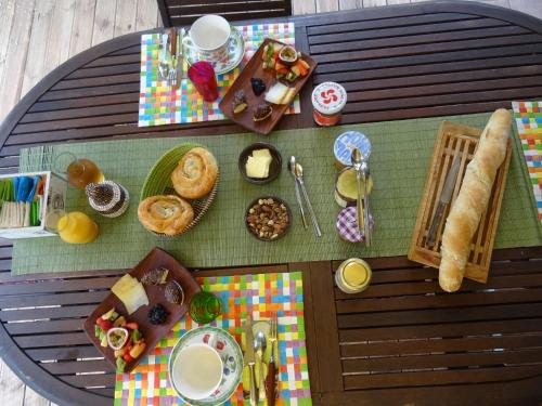 a table with breakfast foods and drinks on it at La Chambre Du Voyageur in Soustons