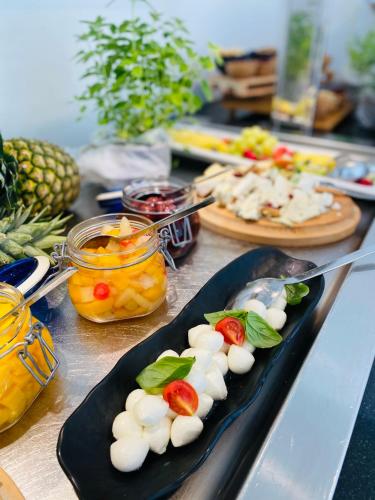a table topped with plates of food with fruit at Aparthotel Miramare in Makarska