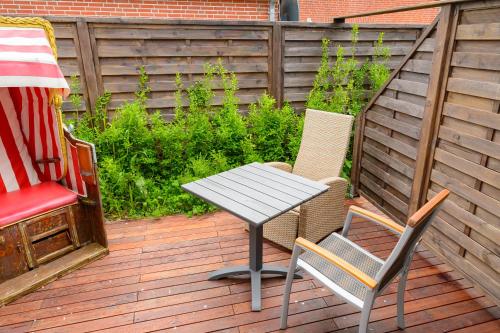 a table and two chairs on a wooden deck at Nordsee-Pension Dagebüll in Dagebüll