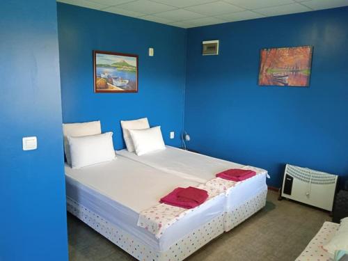 a blue room with a bed with two red towels on it at Draganov House in Durankulak