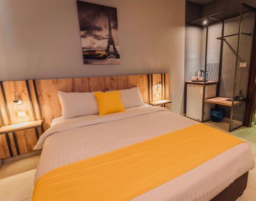 a bedroom with a large bed with a yellow pillow at Baden Hotel Suites in Amman