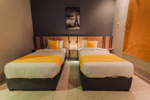 a room with two beds with yellow sheets at Baden Hotel Suites in Amman