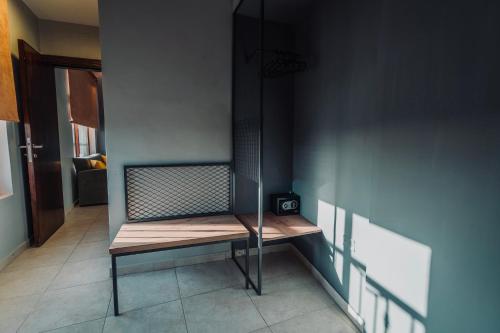 a wooden bench sitting in a room with a wall at Baden Hotel Suites in Amman