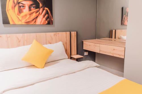 a bedroom with a bed and a painting of a woman at Baden Hotel Suites in Amman
