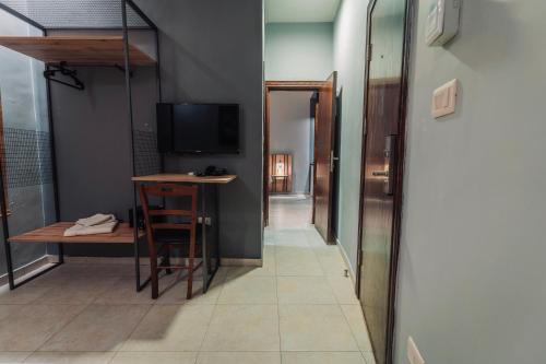 a hallway with a table and a television in a room at Baden Hotel Suites in Amman