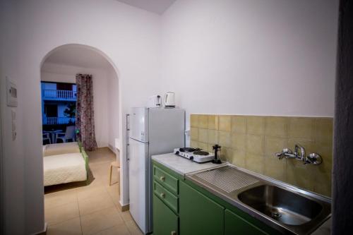 una cucina con lavandino e frigorifero di Christina studios a Laganas