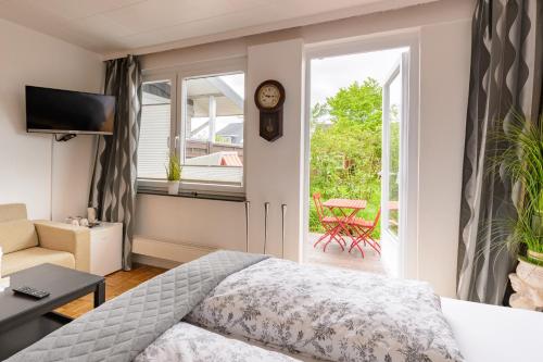 a hotel room with a bed and a sliding glass door at Pension Louisa in Dagebüll