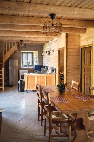 une grande cuisine avec une table et des chaises en bois dans l'établissement La Bastide de la Reine Margot, à Beaumont