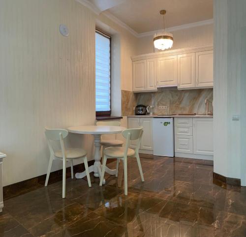 a kitchen with a table and chairs in a room at Кайзервальд Клуб in Karpaty