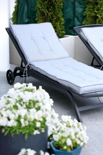 a bench and flowers on a patio with plants at Maritime Residence in Międzyzdroje