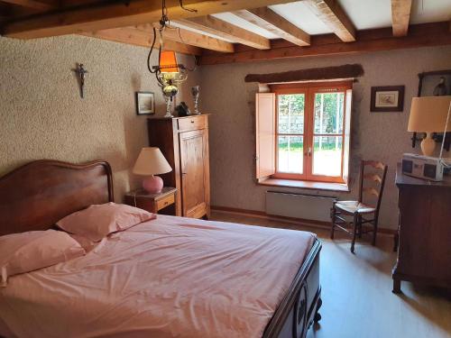 um quarto com uma cama e uma janela em maison authentique 2 à 8 personnes em Uncey-le-Franc