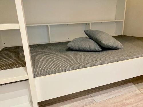 two pillows sitting on top of a bunk bed at L'HERMITAGE - Studio moderne - Piscine - Ascenseur - Quart Golf in La Grande-Motte