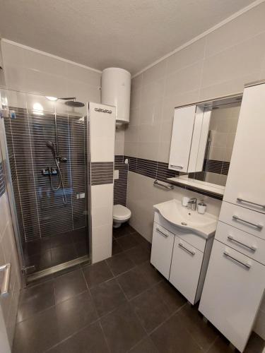 a bathroom with a shower and a sink and a toilet at Apartments Matić in Baška Voda