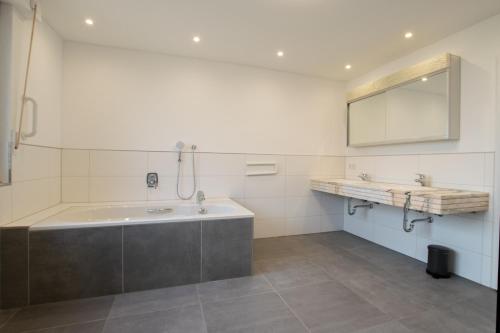 baño con bañera grande y 2 lavabos en Tolstov House - Freistehendes 9 Zimmer Haus mit großem Garten, en Pulheim