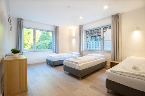 una habitación de hospital con dos camas y dos ventanas en Tolstov House - Freistehendes 9 Zimmer Haus mit großem Garten, en Pulheim