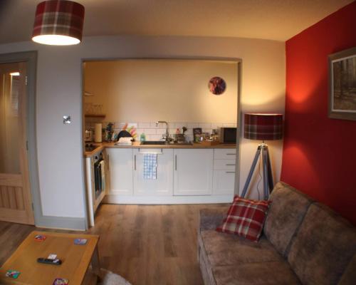 a living room with a couch and a kitchen at Immaculate 1 Bed Apartment in Pitlochry Scotland in Pitlochry