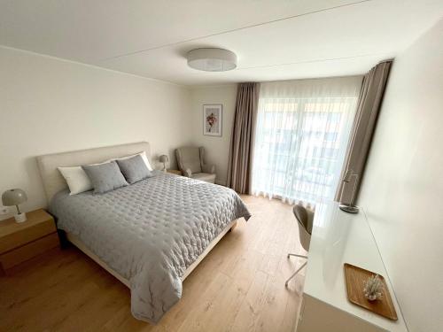 a white bedroom with a bed and a window at Modern City Center Apartment in Tallinn