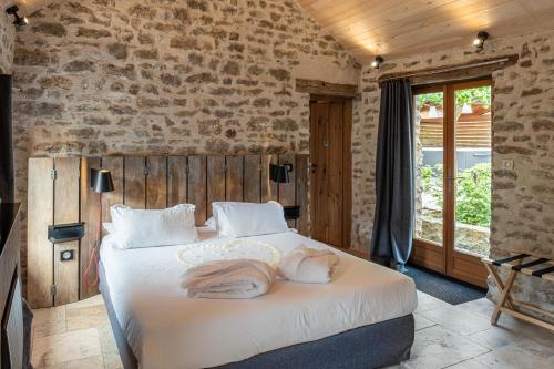 Tempat tidur dalam kamar di Le Domaine des Prés Verts Suites & Chambres avec Jacuzzi Privatif