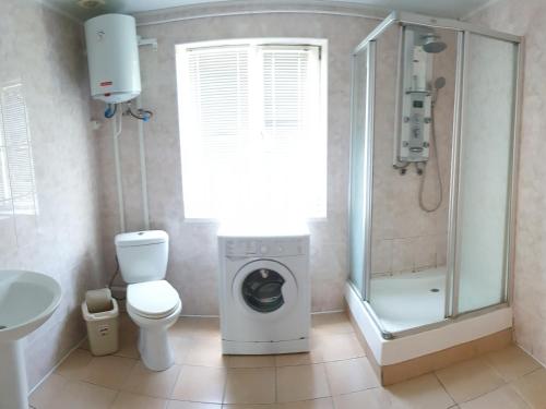 a bathroom with a washing machine and a toilet at Коттедж на базе отдыха у реки с. Кудашевка in Kudashevka