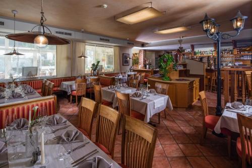 a restaurant with tables and chairs in a room at Apparthaus & Chalets Hofer in Zell am Ziller