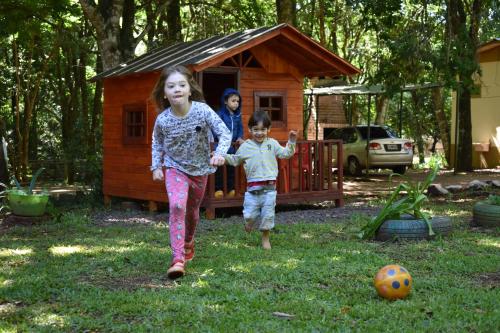 two children playing in front of a dog house at Cabañas Oberá in Oberá
