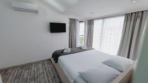 a bedroom with a large bed with a large window at Seaside Apartment Batumi Beach in Batumi