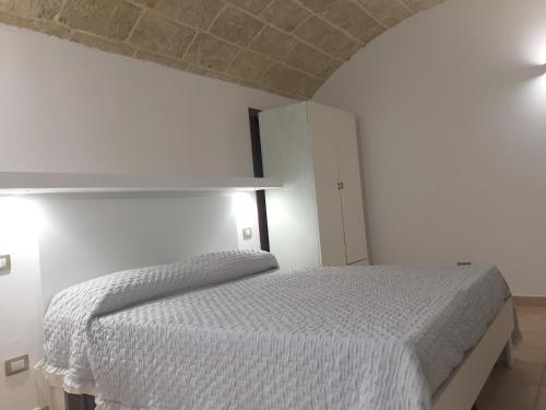 a bedroom with a white bed in a white room at Ugento Dimora in Ugento