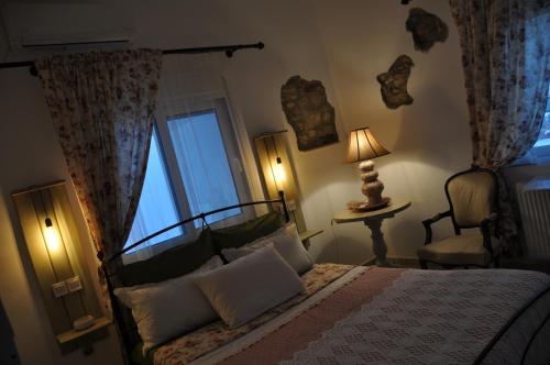 a bedroom with a bed and a chair and a window at KD Vintage Home in Lavrio