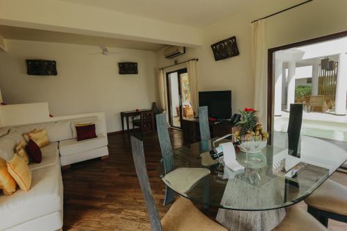 a living room with a glass table and a couch at Essque Zalu Zanzibar in Nungwi