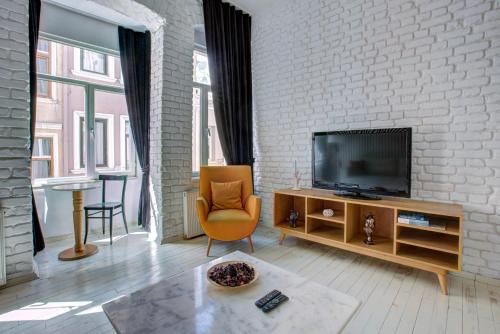 a living room with a television and a brick wall at Maravilloso Hotel Galata in Istanbul
