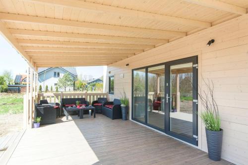 an outdoor patio with a wooden ceiling and glass doors at Cherry House Gdańsk in Gdańsk